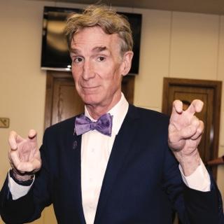 访问ing author 和 television host Bill Nye holds up both h和s in 的 two-fingered Go Frogs h和 gesture.